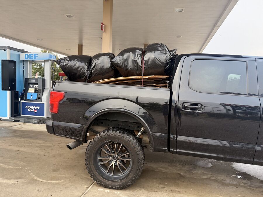 Truck bed loaded with bagged trash and flattened cardboard for a junk removal run