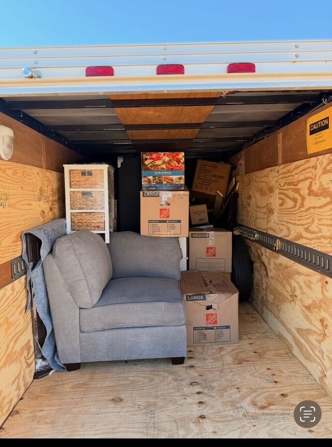 Inside the enclosed cargo trailer loaded with a couch and moving boxes